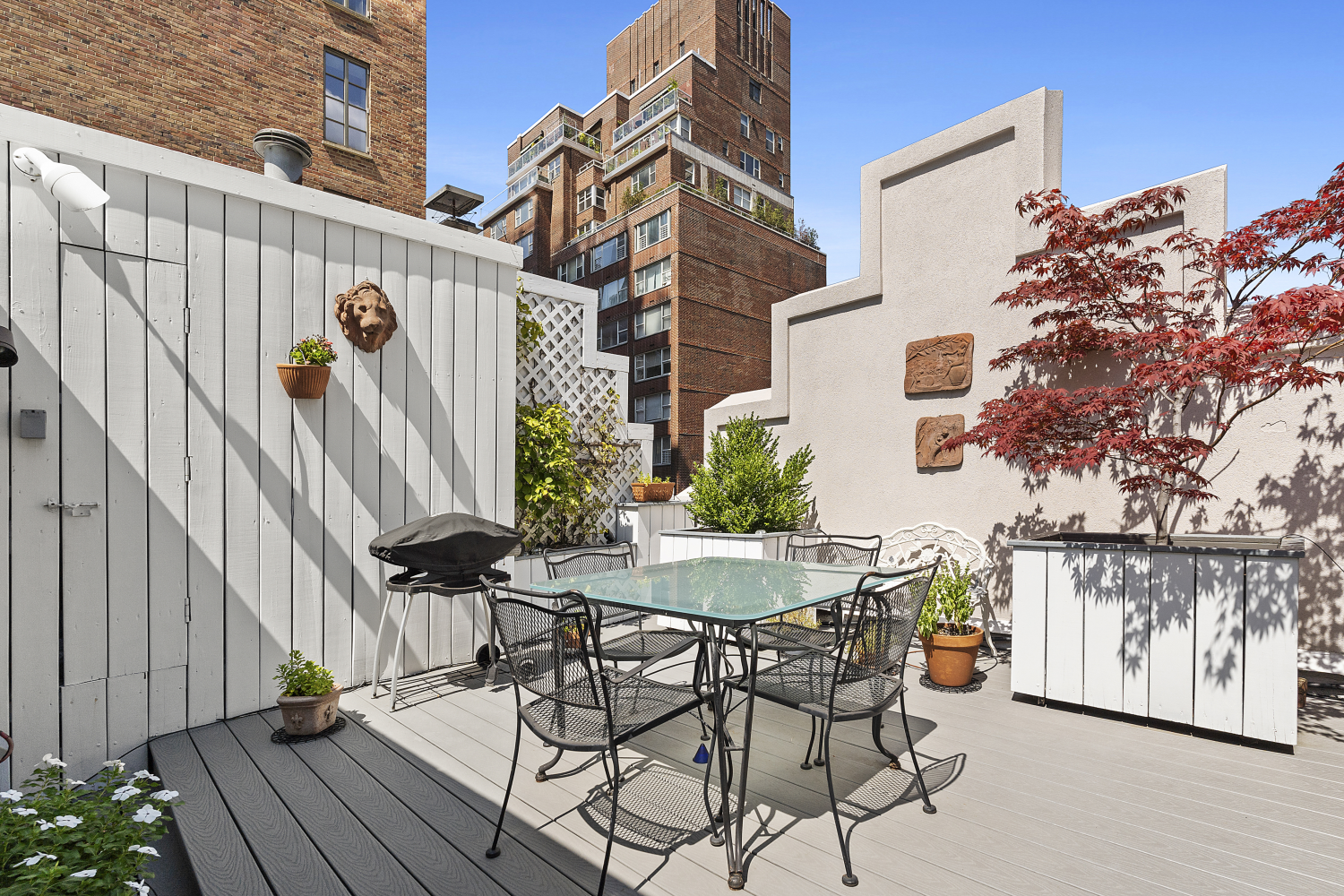 152 East 63rd Street, Unit 2 Manhattan, NY 10065 - Photo 7 of 23 a view of a patio with table and chairs with wooden floor and fence