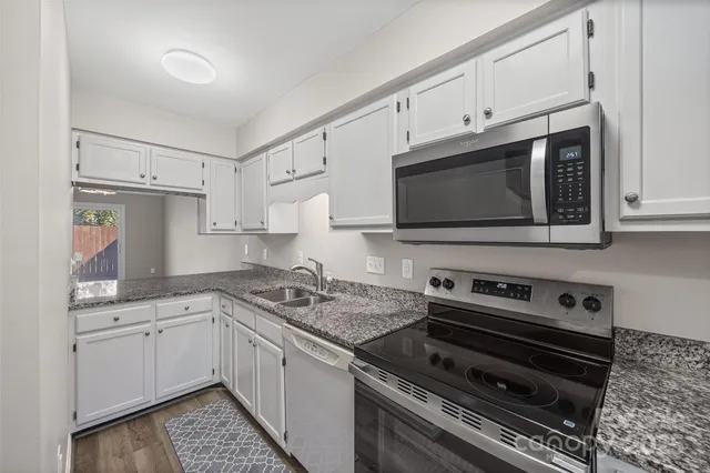 a kitchen with cabinets stainless steel appliances and a counter space
