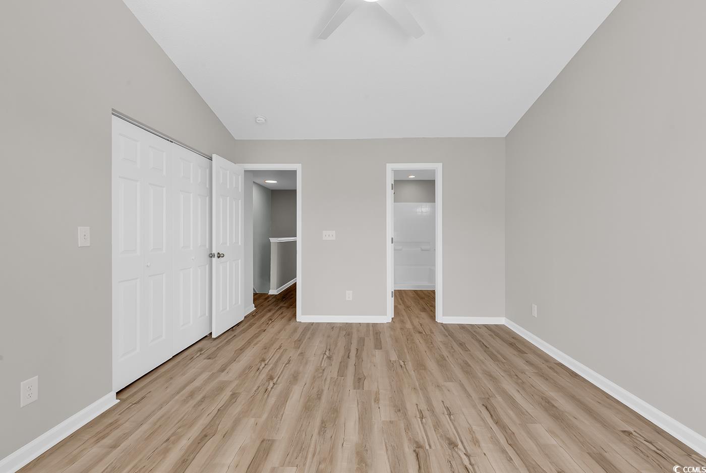 308 Kiskadee Loop, Unit E Conway, SC 29526 - Photo 19 of 36 Unfurnished bedroom with a closet, light wood-type flooring, connected bathroom, and ceiling fan