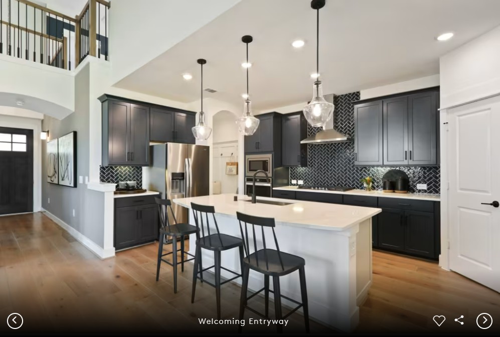 2913 Zuni Path Leander, TX 78641 - Photo 4 of 17 a kitchen with stainless steel appliances kitchen island granite countertop a stove a sink a refrigerator and chairs with wooden floor