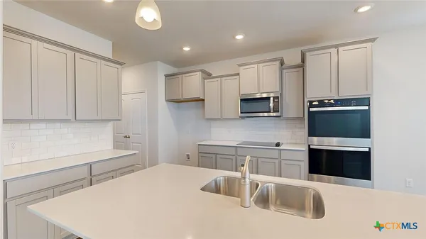 a kitchen that has a sink and a stove top oven