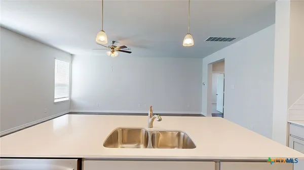 a kitchen with a stove and wooden floor
