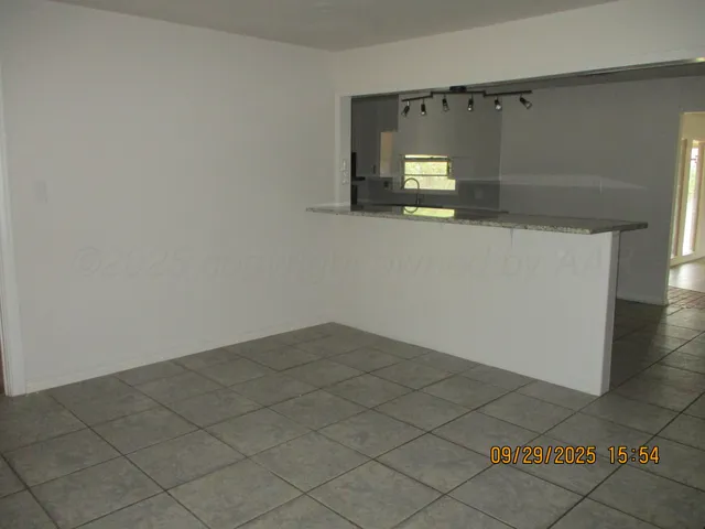 an empty room with wooden floor and mirror