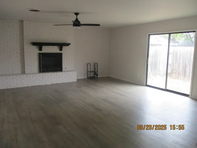 an empty room with windows and fireplace