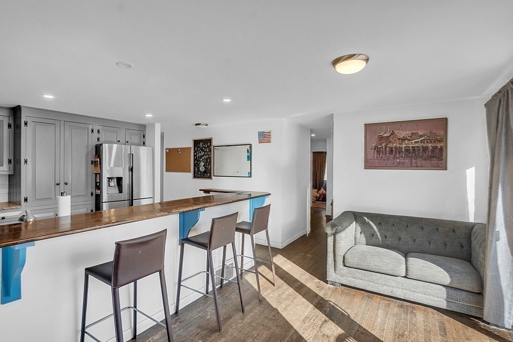 84 Powers Road Westford, MA 01886 - Photo 35 of 42 a living room with stainless steel appliances kitchen island granite countertop furniture and a view of kitchen