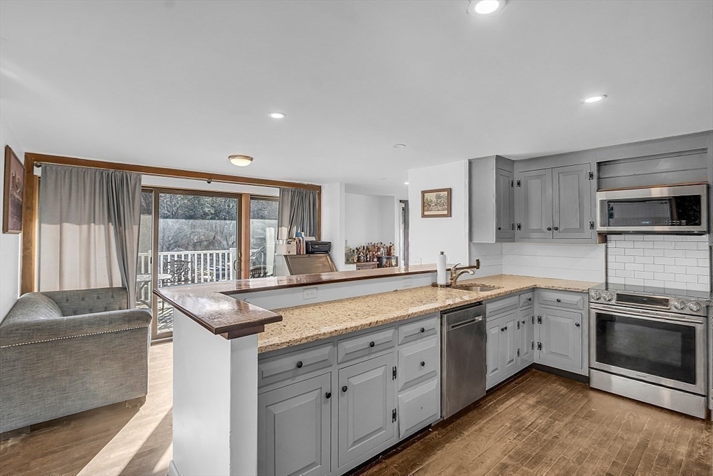 84 Powers Road Westford, MA 01886 - Photo 36 of 42 a kitchen with stainless steel appliances granite countertop a sink and stove top oven