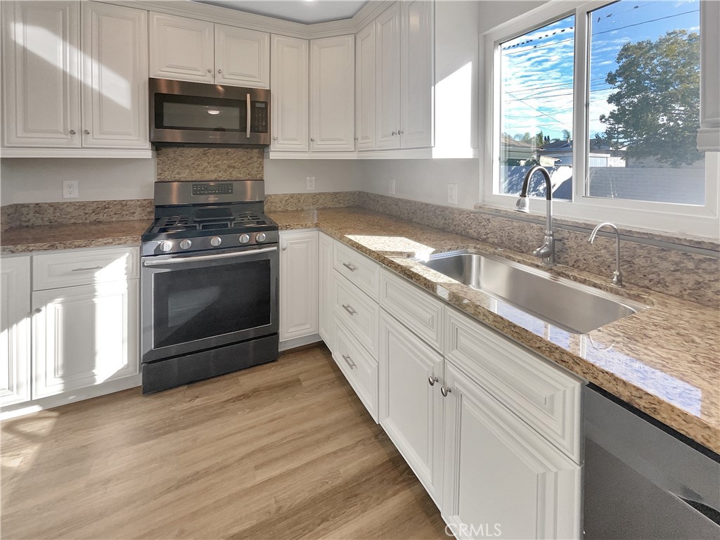 380 Harvard Street Oxnard, CA 93036 - Photo 6 of 14 a kitchen with granite countertop a sink stove and cabinets