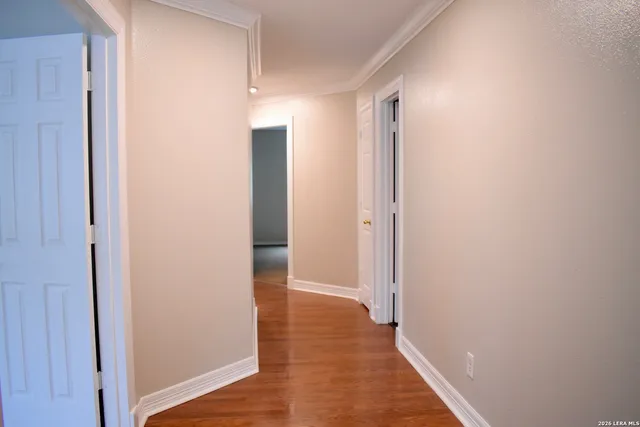 a view of hallway with closet and wooden floor
