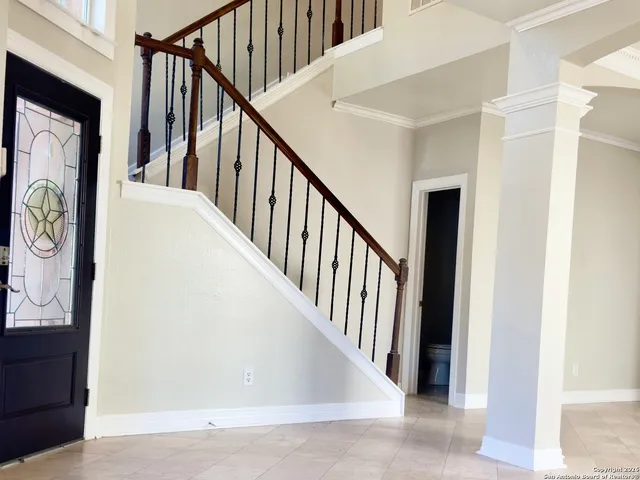 a view of staircase with lots of frames on wall and windows