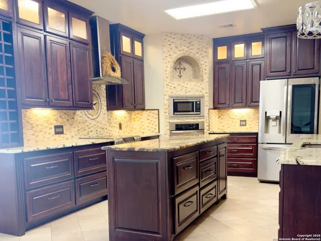 a kitchen with stainless steel appliances granite countertop a stove and cabinets