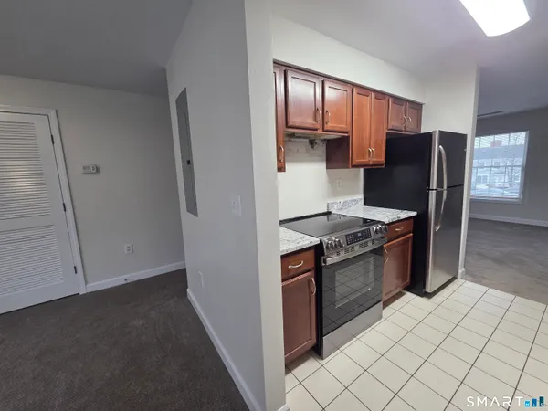 a kitchen with stainless steel appliances granite countertop a refrigerator and a stove top oven