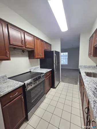 a kitchen with granite countertop a stove top oven and cabinets