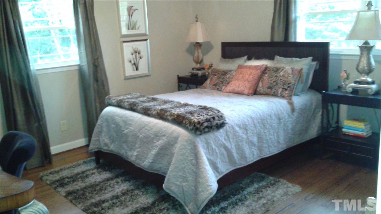 204 Sampson Street Raleigh, NC 27609 - Photo 13 of 22 a bedroom with a bed and wooden floor