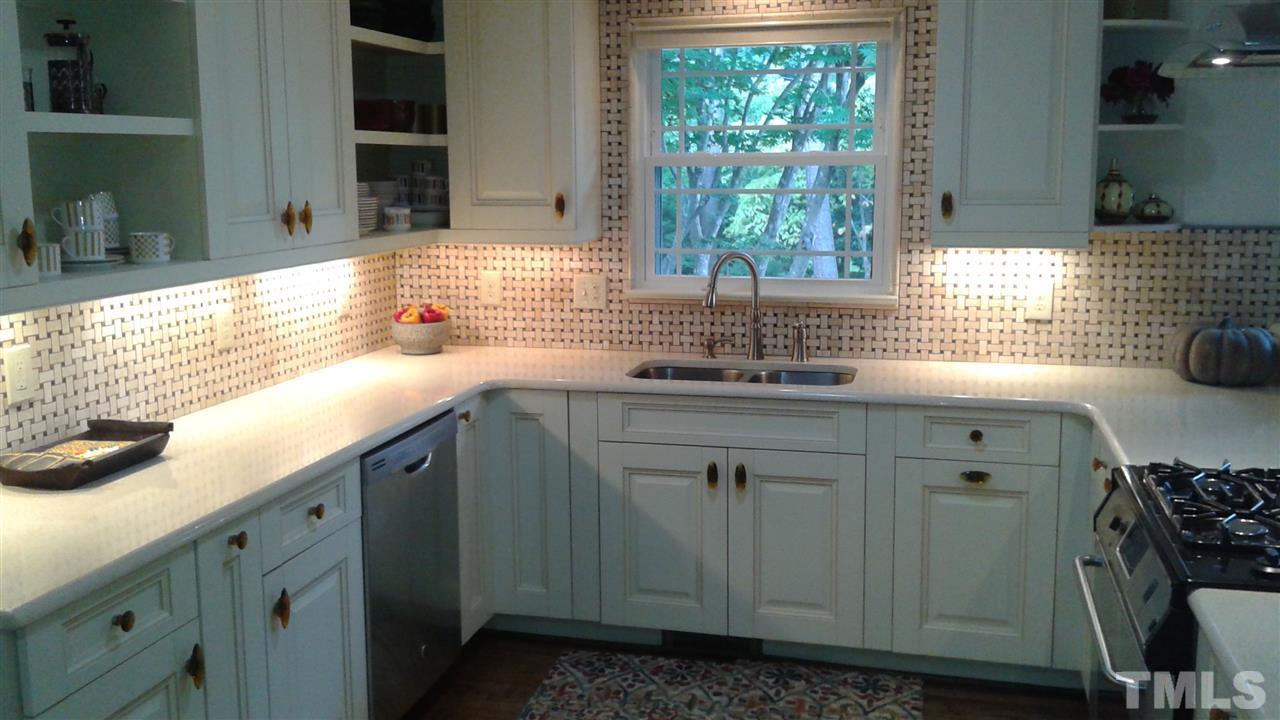 204 Sampson Street Raleigh, NC 27609 - Photo 8 of 22 a kitchen with granite countertop a sink a window and cabinets