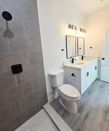 a bathroom with a toilet a sink and mirror