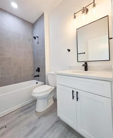 a bathroom with a bathtub shower sink vanity and toilet