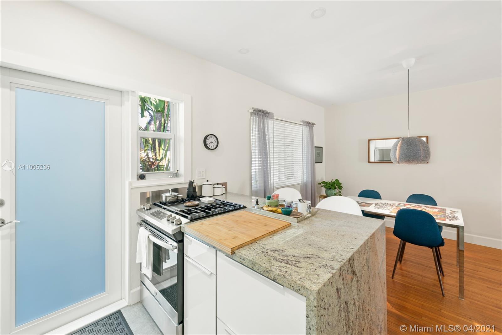 4780 Pine Tree Drive, Unit 9 Miami Beach, FL 33140 - Photo 10 of 21 a kitchen that has a stove and a table in it