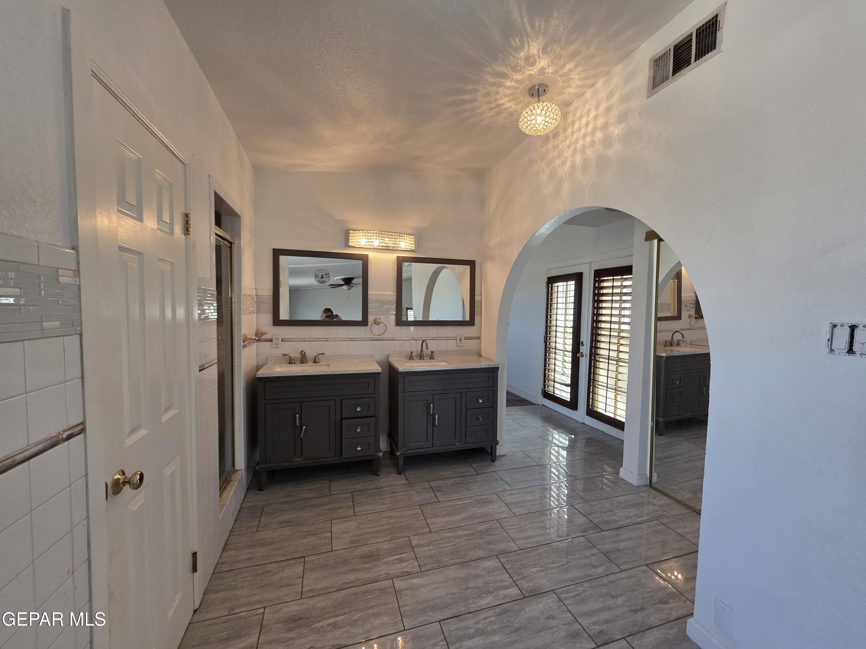 11661 Socorro Road Socorro, TX 79927 - Photo 31 of 32 a large bathroom with a double vanity sink a large mirror and a bathtub