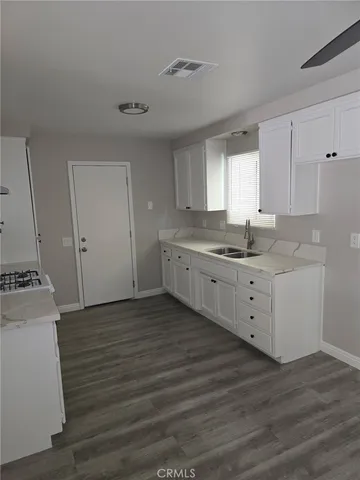 a kitchen with a sink cabinets and wooden floor