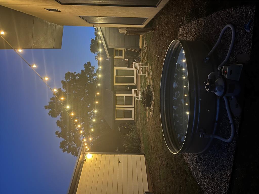 4619 Jinx Avenue, Unit A Austin, TX 78745 - Photo 2 of 21 Exterior yard area featuring a galvanized stock tank pool on a gravel pad, overhead string lights, and a fire pit