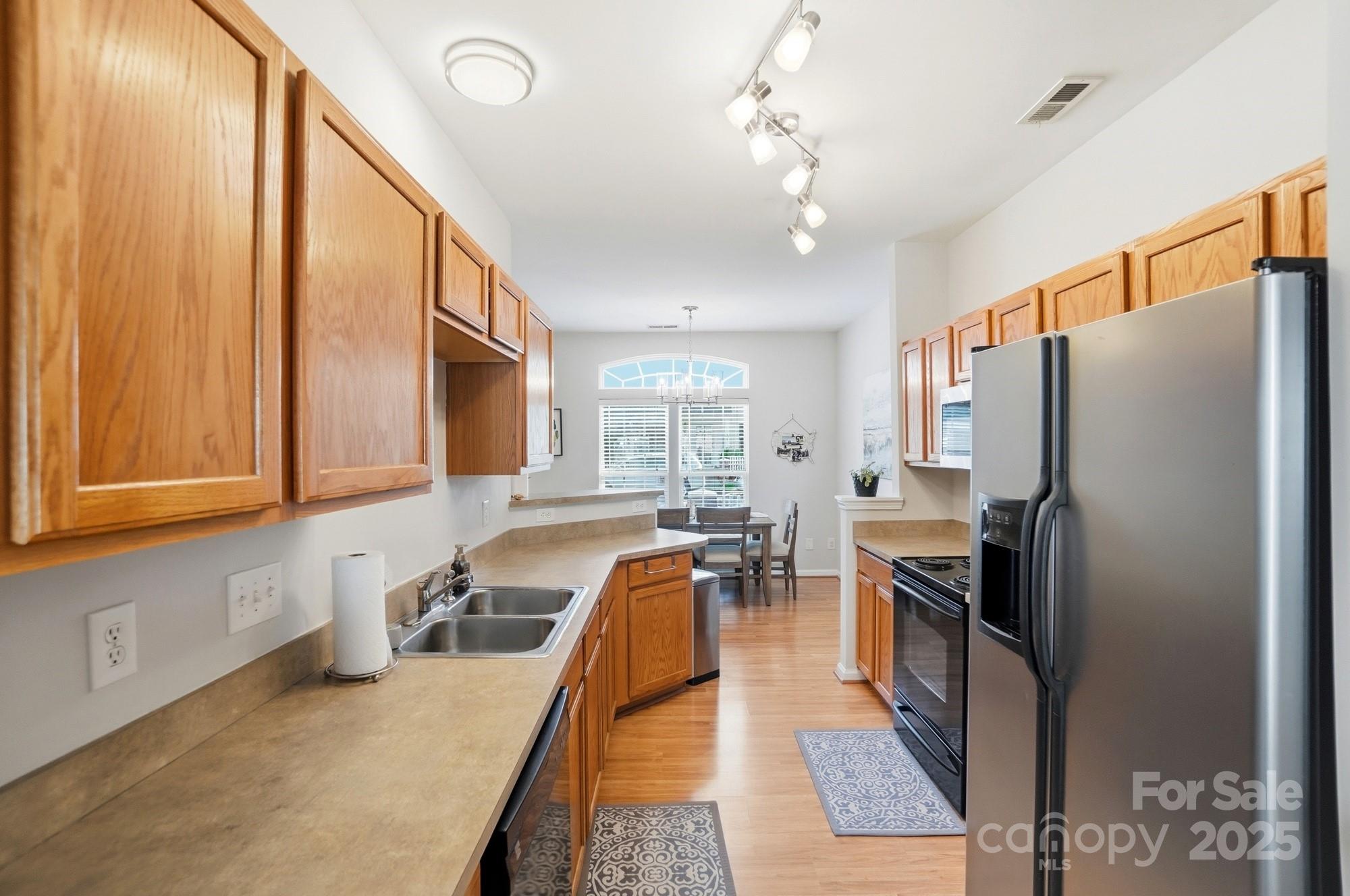 837 Dillard Road Rock Hill, SC 29730 - Photo 12 of 48 a kitchen with stainless steel appliances granite countertop a refrigerator a sink dishwasher a stove and white cabinets with wooden floor
