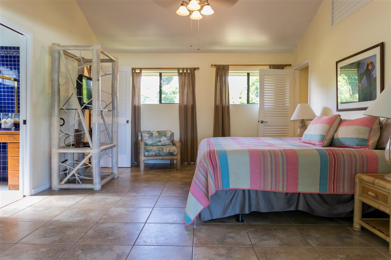 1555 West Kuiaha Road Haiku, HI 96708 - Photo 14 of 30 a bedroom with a bed and a chandelier