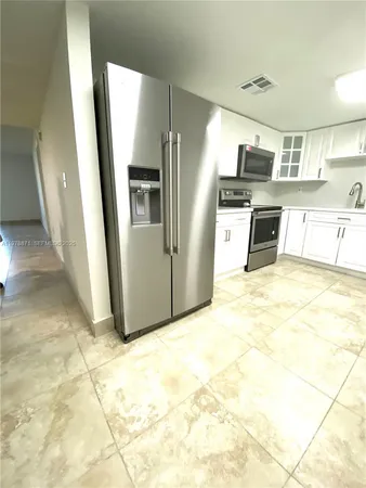 a kitchen with stainless steel appliances a refrigerator and a stove top oven