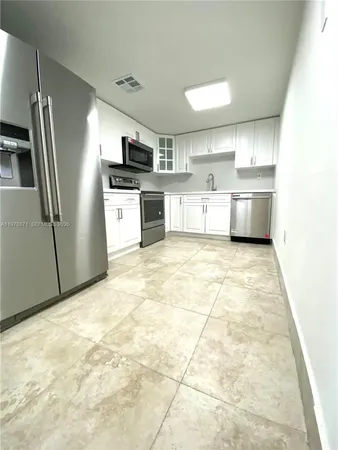 a kitchen with stainless steel appliances granite countertop a refrigerator sink and cabinets