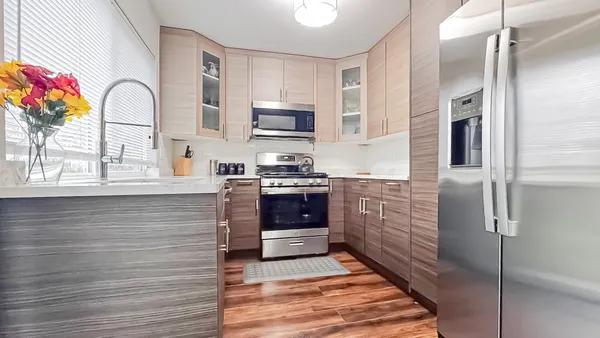 a kitchen with stainless steel appliances kitchen island granite countertop a refrigerator and a stove top oven