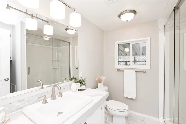 a bathroom with a sink a toilet and mirror
