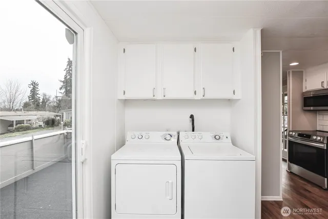 a view of washer and dryer with kitchen in the background
