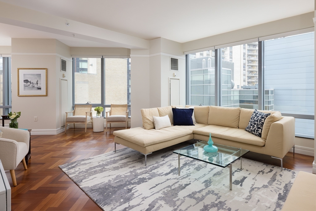 1 Avery Street, Unit 12A Boston, MA 02111 - Photo 1 of 14 a living room with furniture large windows and wooden floor