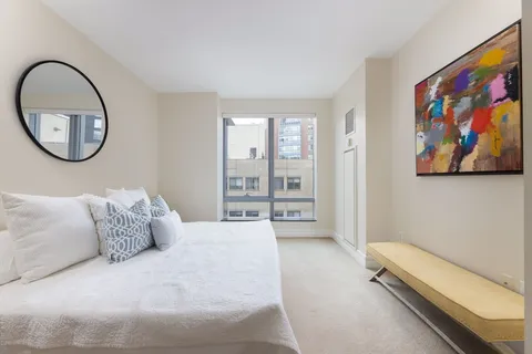 a spacious bedroom with a bed and a painting on the wall