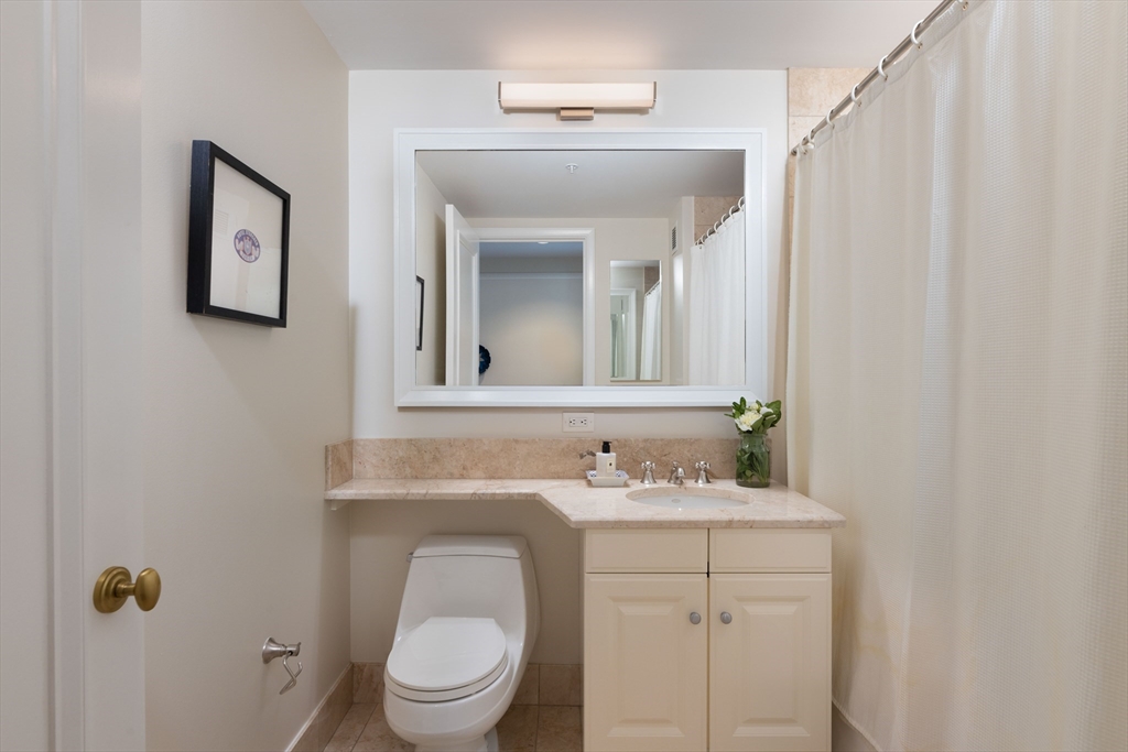 1 Avery Street, Unit 12A Boston, MA 02111 - Photo 13 of 14 a bathroom with a toilet sink and mirror