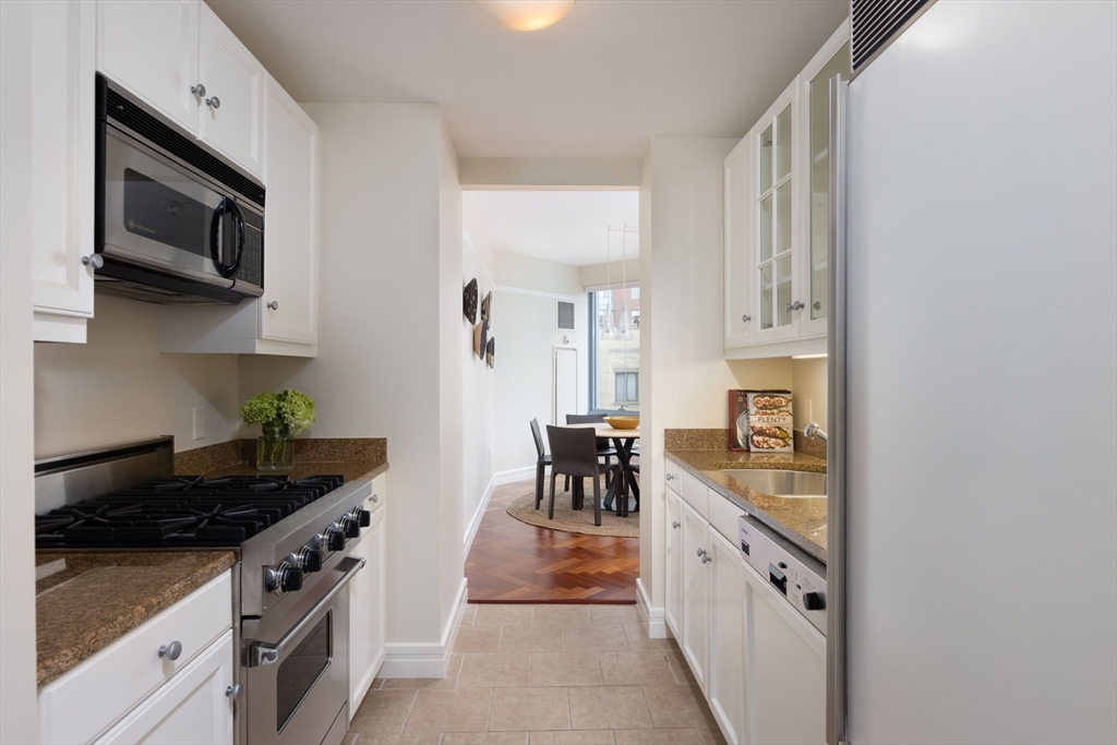 1 Avery Street, Unit 12A Boston, MA 02111 - Photo 5 of 14 a kitchen with stainless steel appliances a sink stove and cabinets