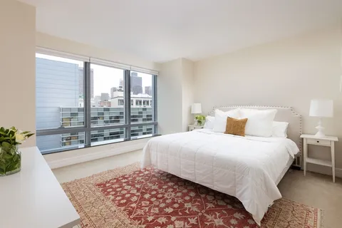 a bedroom with a large bed and a large window
