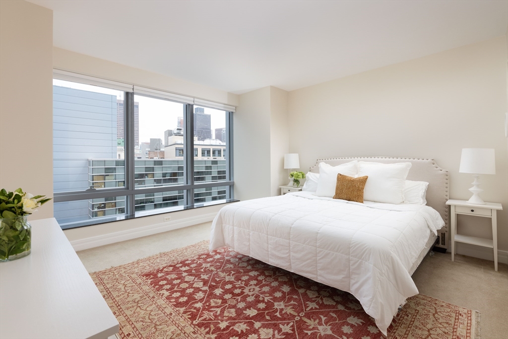 1 Avery Street, Unit 12A Boston, MA 02111 - Photo 8 of 14 a bedroom with a large bed and a large window