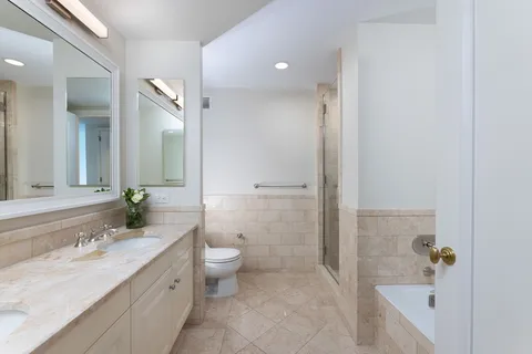 a bathroom with a granite countertop sink a toilet and shower