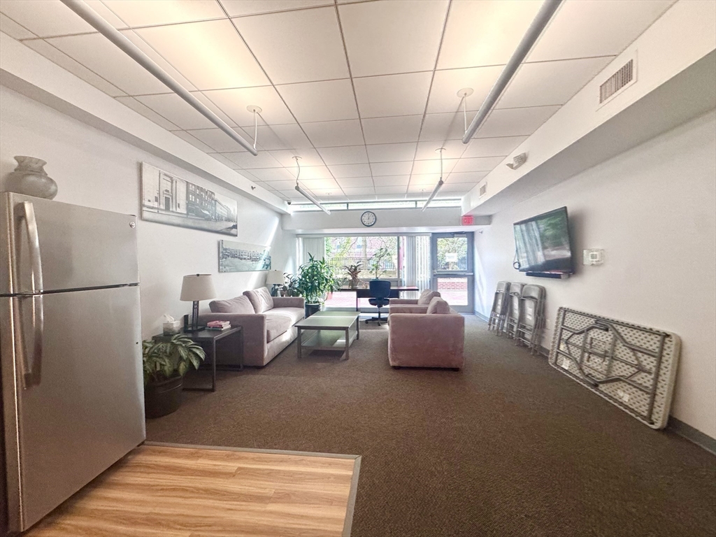 133 Park Street, Unit 404 Brookline, MA 02446 - Photo 17 of 25 a living room with furniture fireplace and a window