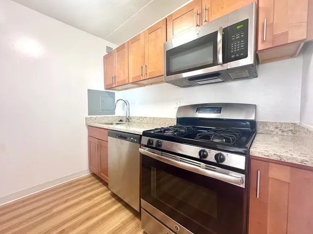 a kitchen with stainless steel appliances granite countertop a stove and a microwave