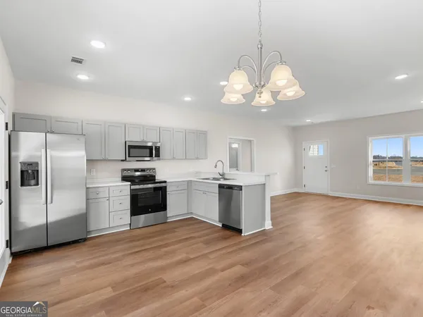 a large kitchen with a center island stainless steel appliances cabinets and a window