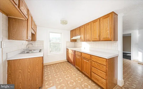 a kitchen with stainless steel appliances granite countertop a sink and a stove top oven