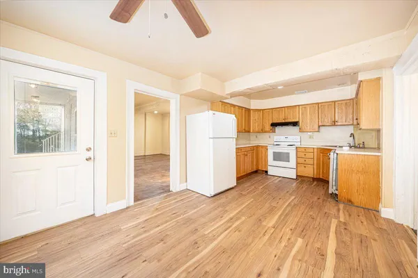 a kitchen with stainless steel appliances granite countertop a stove a sink and white cabinets with wooden floor