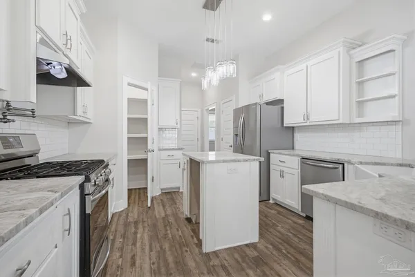 a kitchen with refrigerator stove and sink