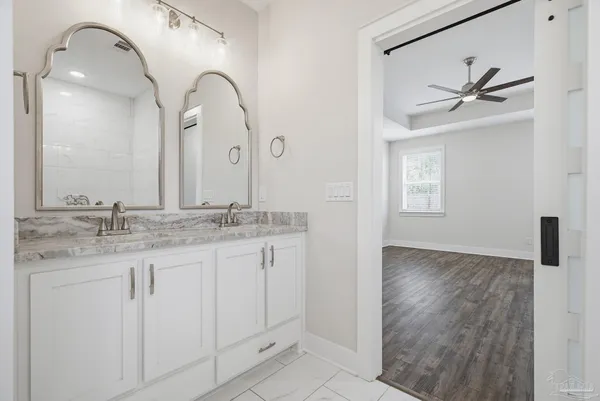 an empty room with wooden floor and a ceiling fan