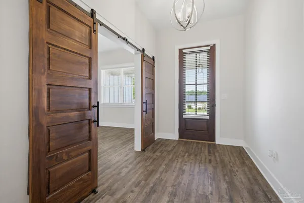 a view of empty room with wooden floor