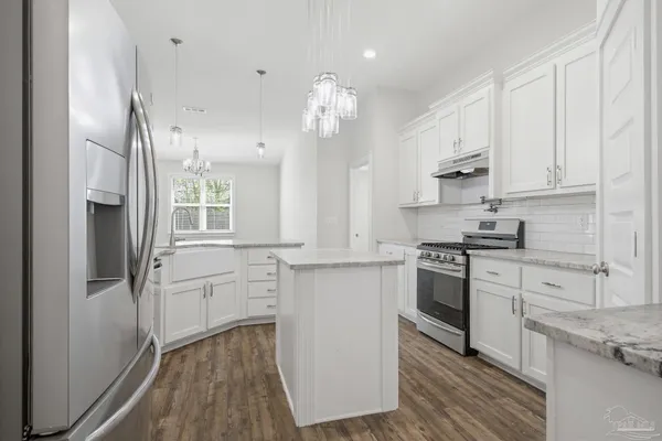 a kitchen with white cabinets and stainless steel appliances