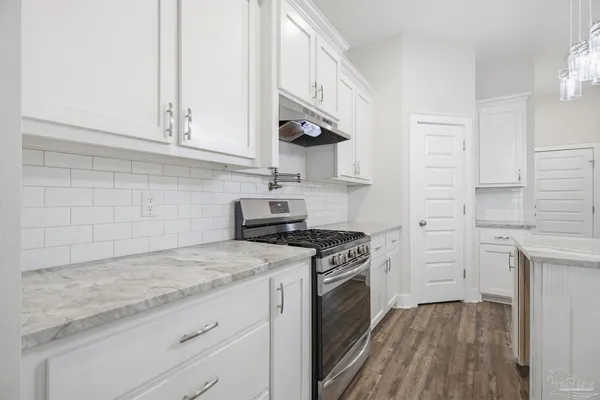 a kitchen with white cabinets and appliances