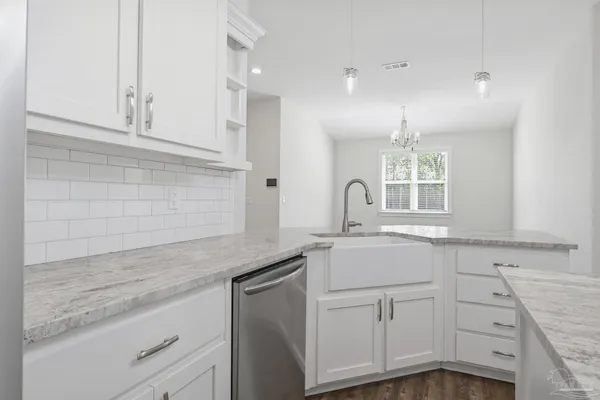 a kitchen with granite countertop white cabinets and white appliances
