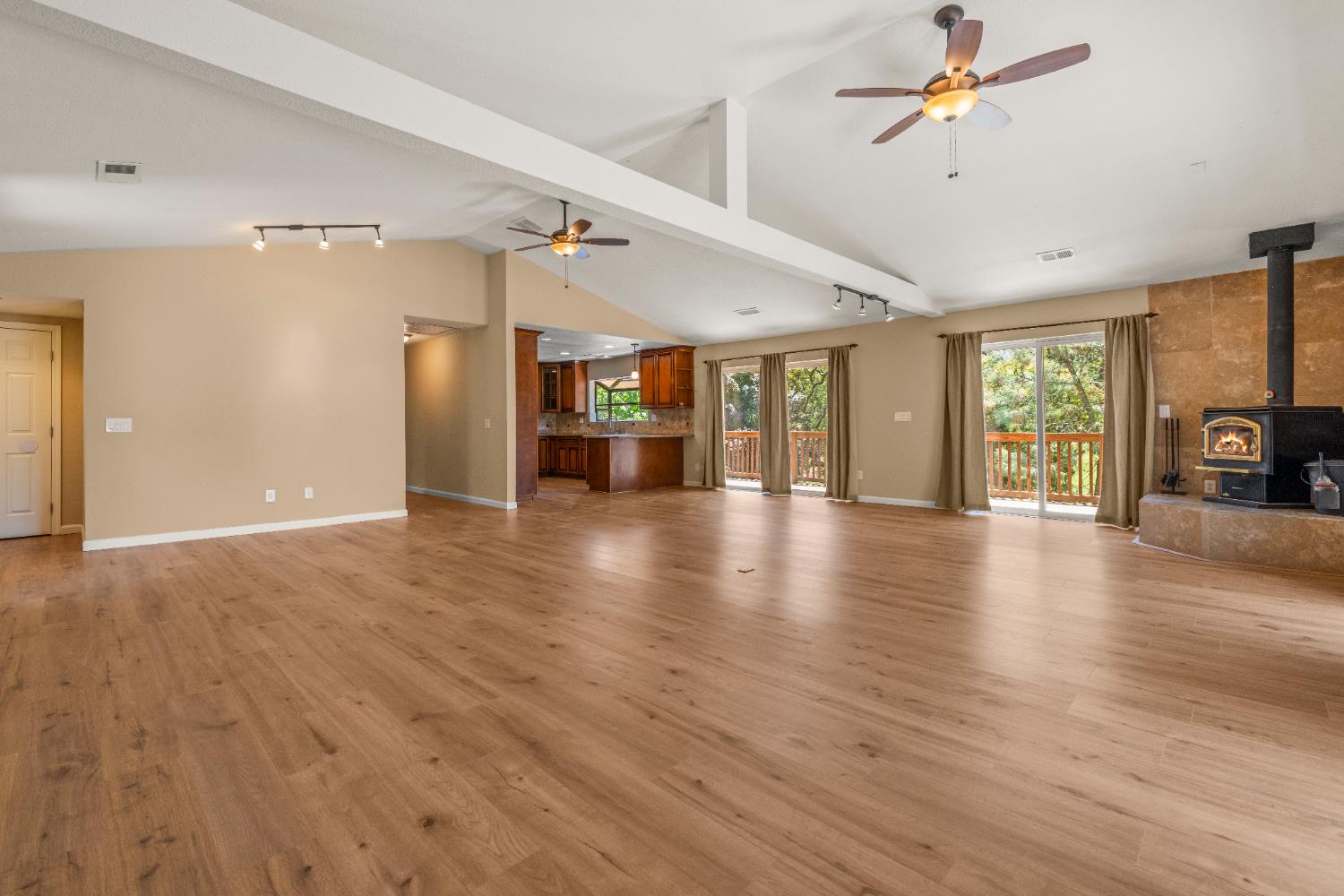 a view of an empty room with a fireplace and wooden floor